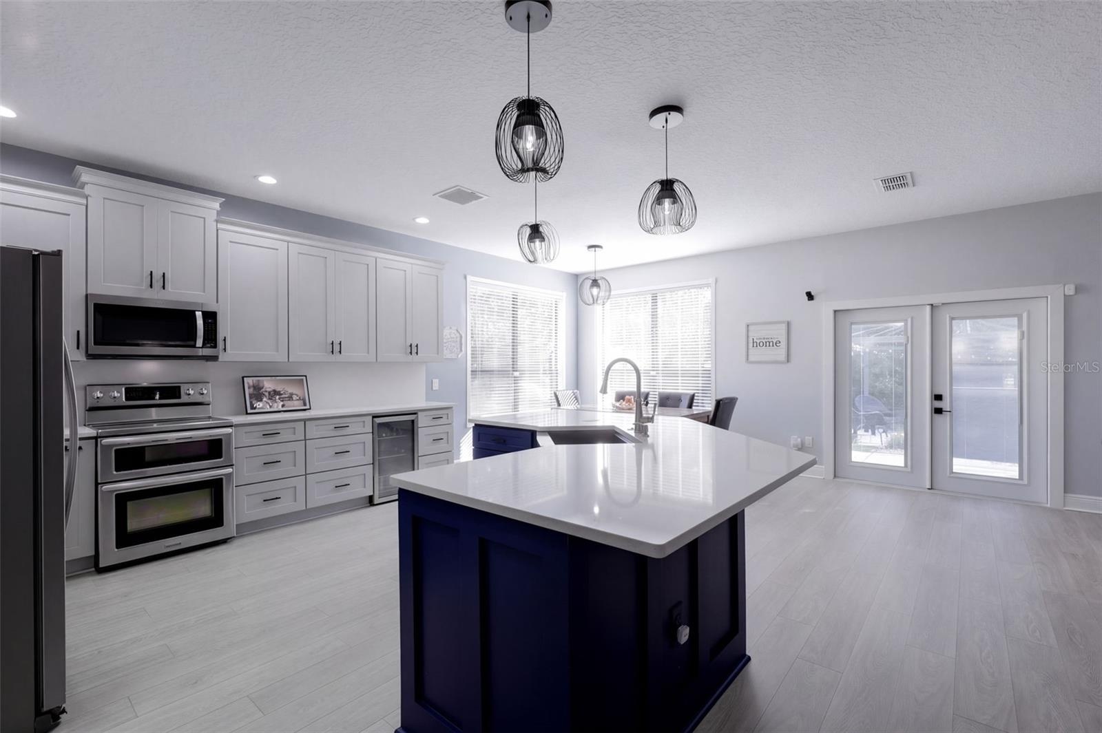 Newly renovated kitchen and large quartz island with stainless steel farmhouse sink