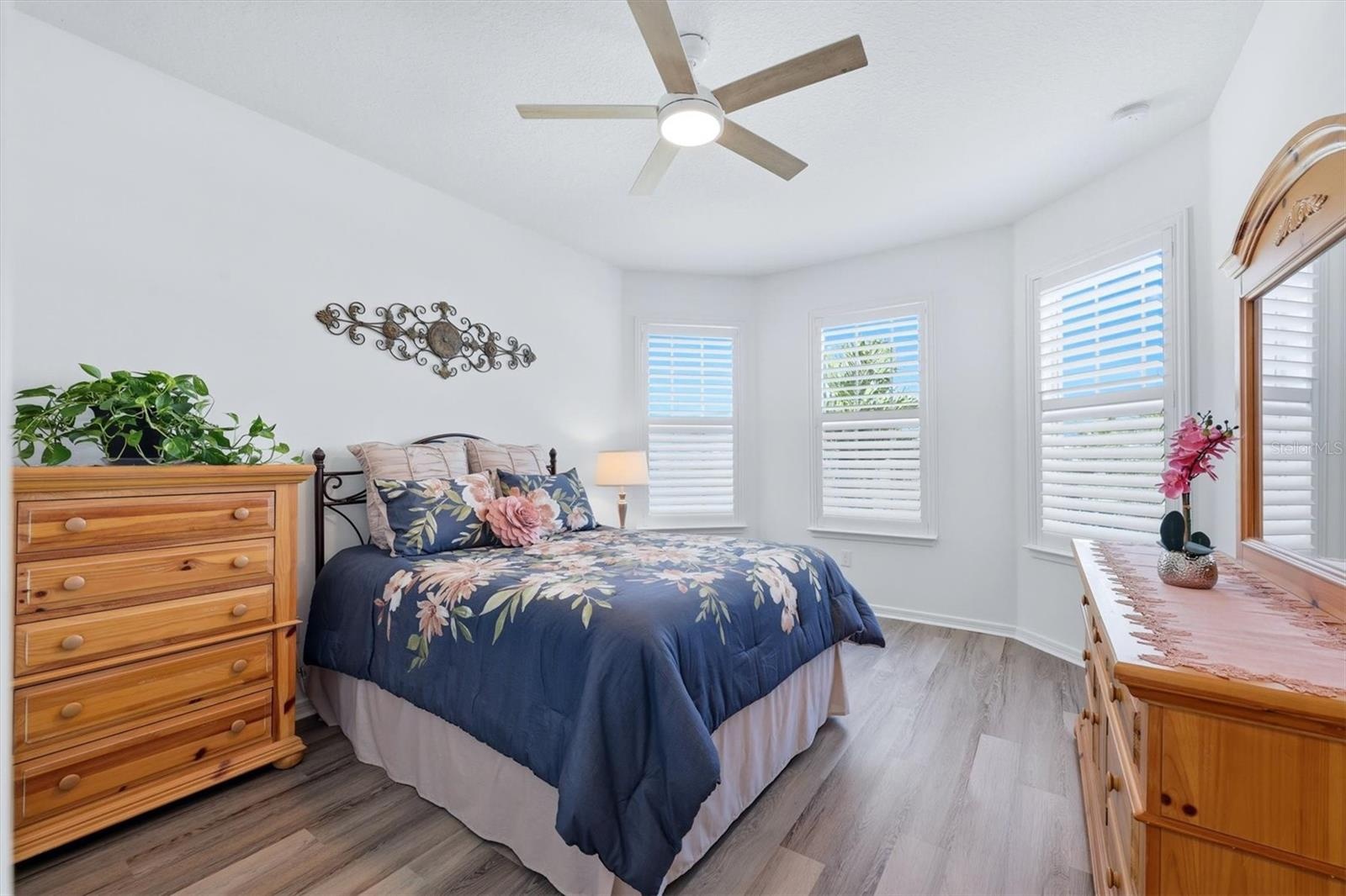 Second Bedroom with newer LPV flooring, ceiling fan and plantation shutters