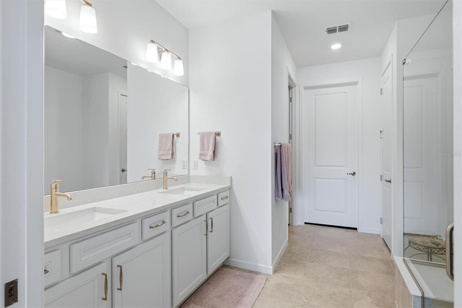 Primary Bath with double sinks, separate room for commode, walk in closet and linen closet.
