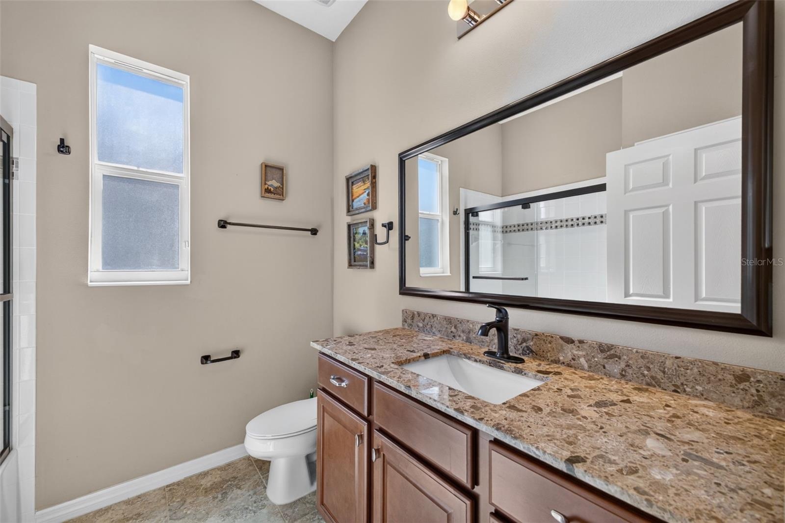 Appointed with rich granite counter surfaces, this third bath features a full tub and shower combination for modern convenience.