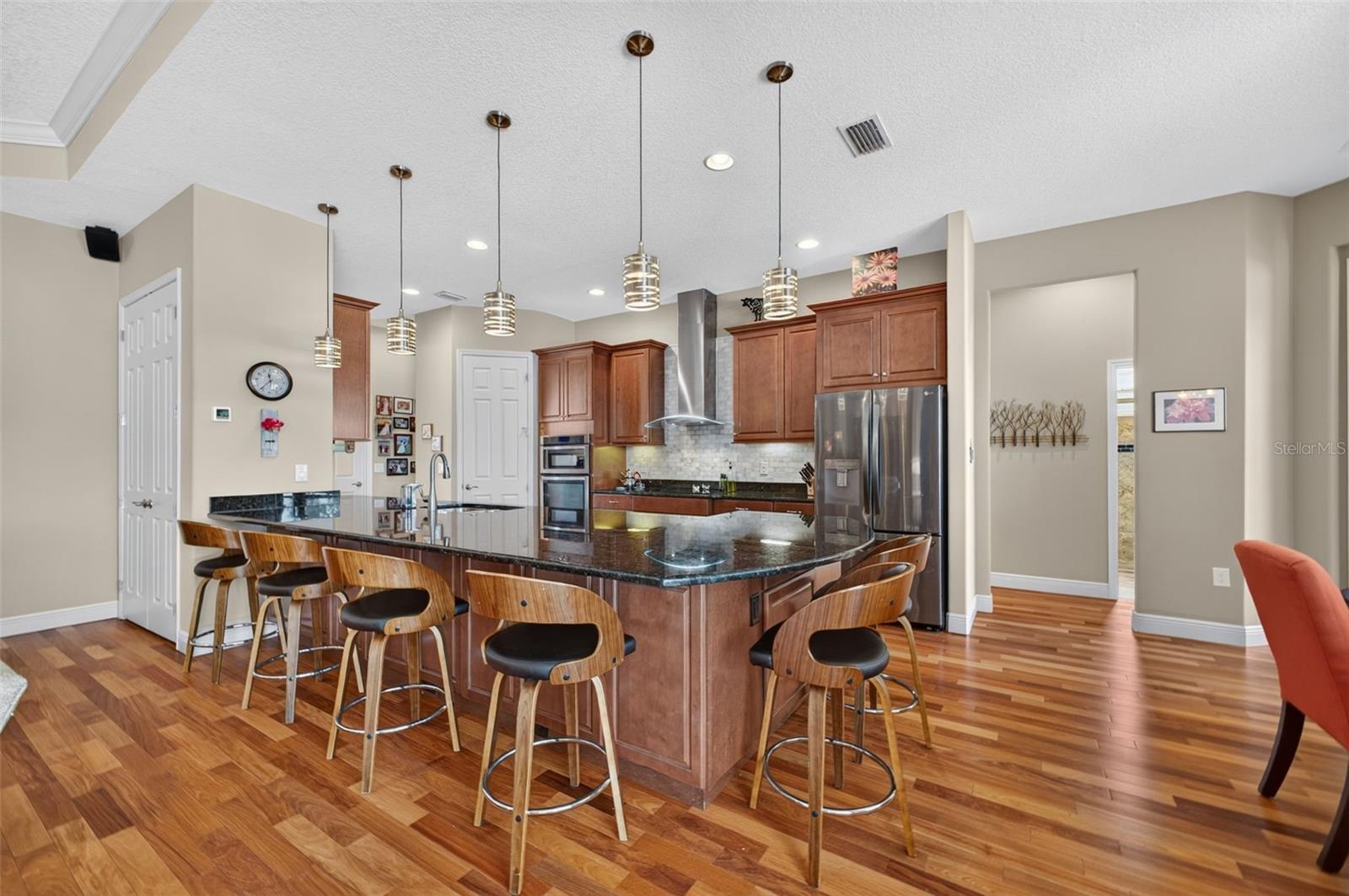 Stylish pendant lights illuminate and accent the spacious kitchen peninsula.