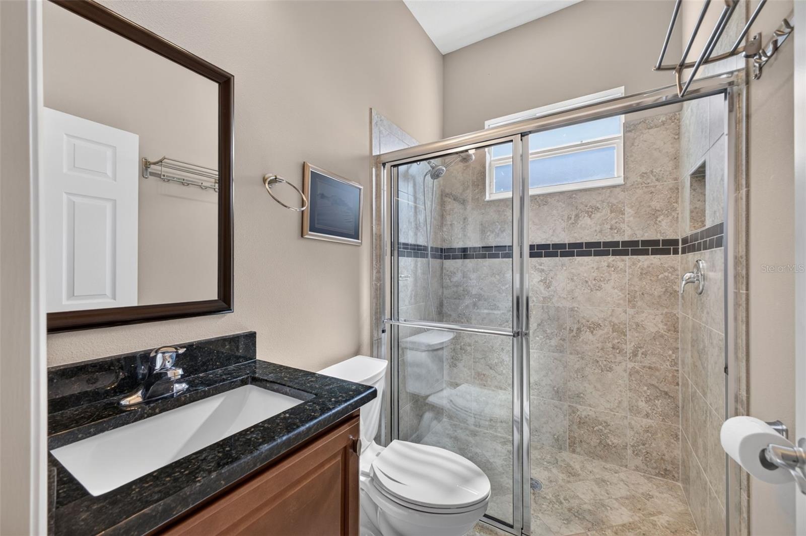 Appointed with rich granite countertops and a glass-enclosed walk-in shower, this second bath combines style and convenience.