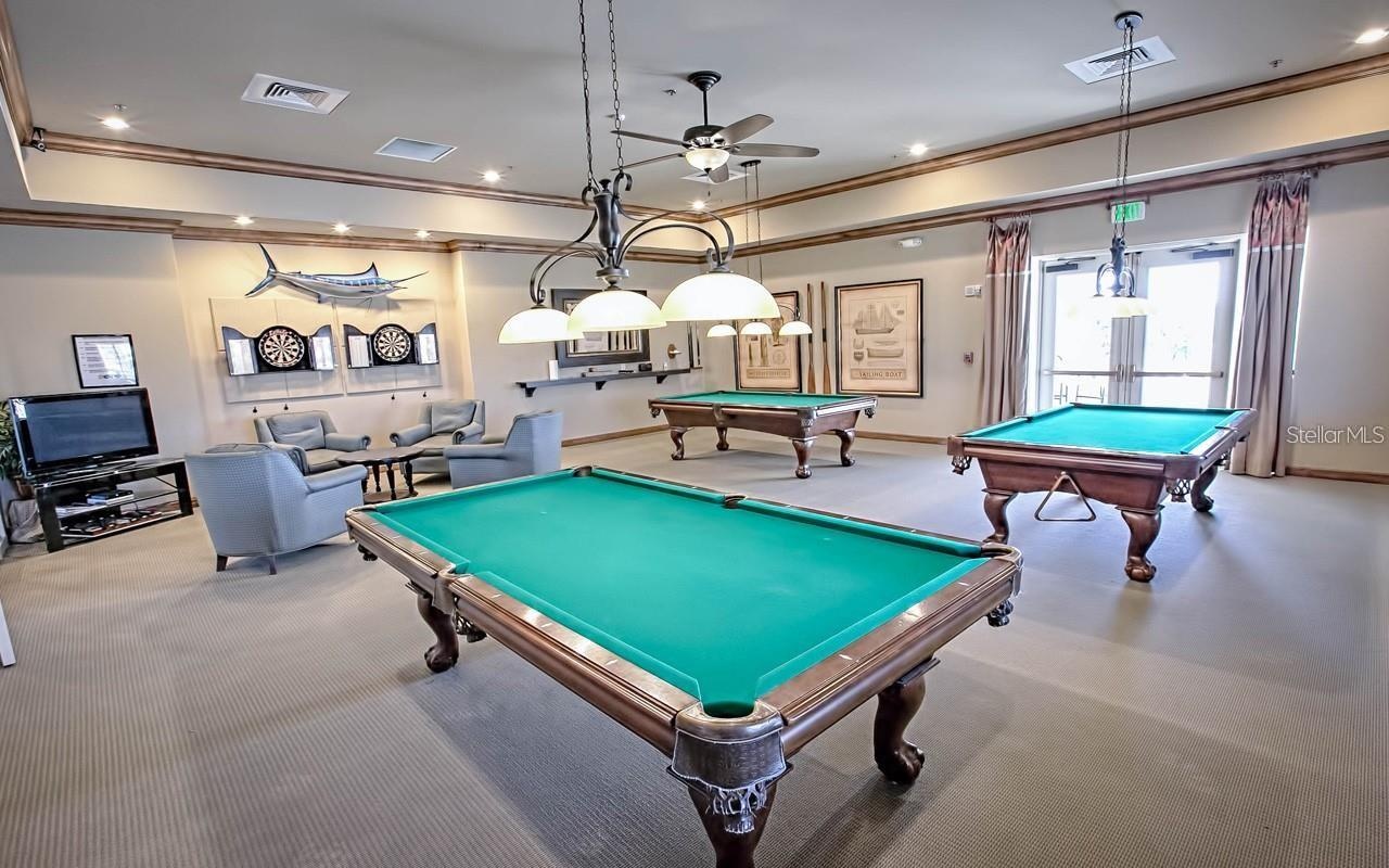 Enjoy a classic game-room experience in the dedicated billiards room, featuring pool tables and comfortable lounge seating.