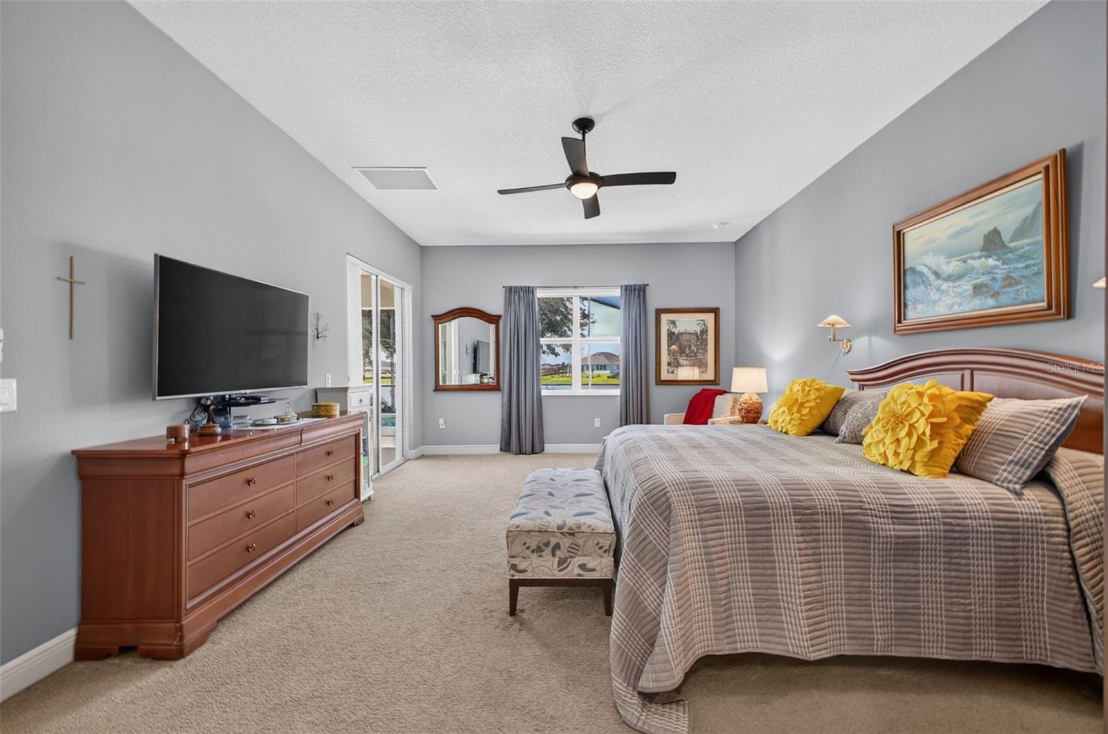 Positioned at the back of the home to capture sweeping lake views, this expansive primary retreat offers seamless indoor-outdoor flow to the pool and 