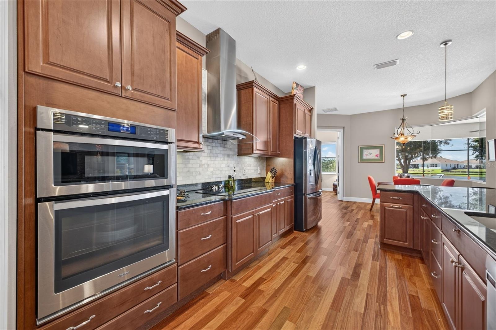 Equipped with a sleek induction cooktop paired with a stylish, exterior-vented range hood for optimal ventilation.