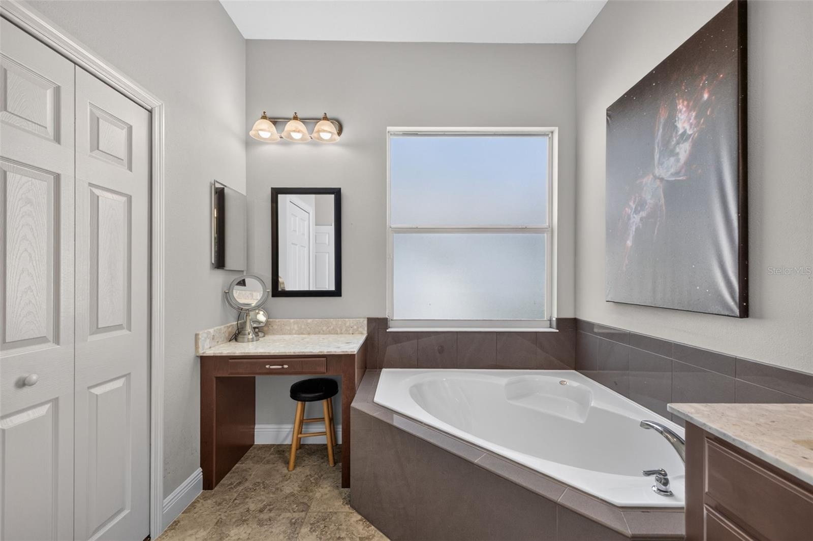 Pamper yourself in an elegant primary bath complete with a built-in makeup vanity and ample closet storage.
