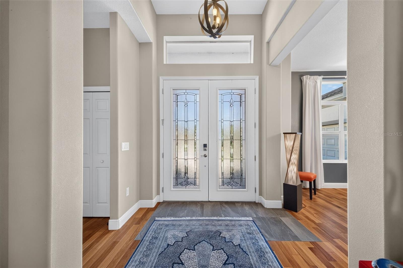 Make a memorable entrance in a dramatic, sun-filled foyer highlighted by soaring ceilings and architectural elegance.