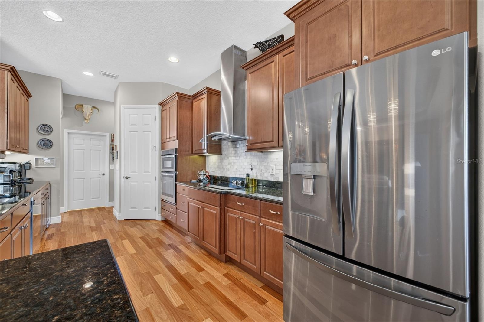 Warm wood floors, sleek stainless steel appliances, and built-in convection microwave and oven units make this kitchen a chef's dream for culinary cre