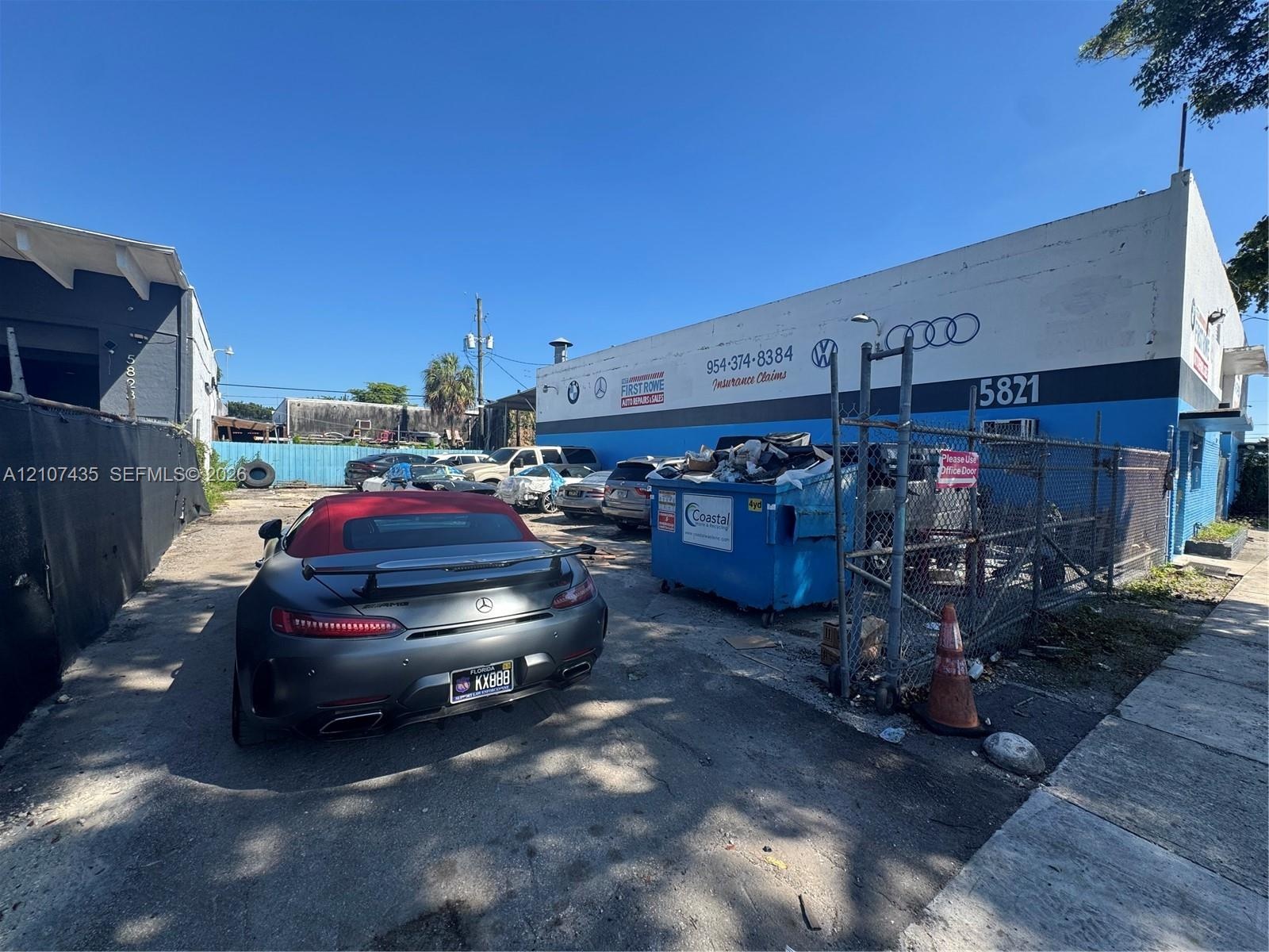 Commercial structure with concrete masonry unit construction, fenced exterior lot, and paved surfacing