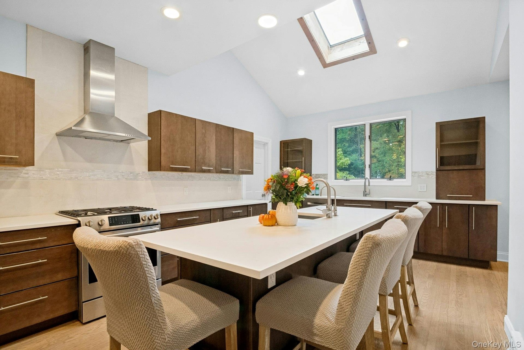 An oversized quartz kitchen island that handles both meal prep and homework.