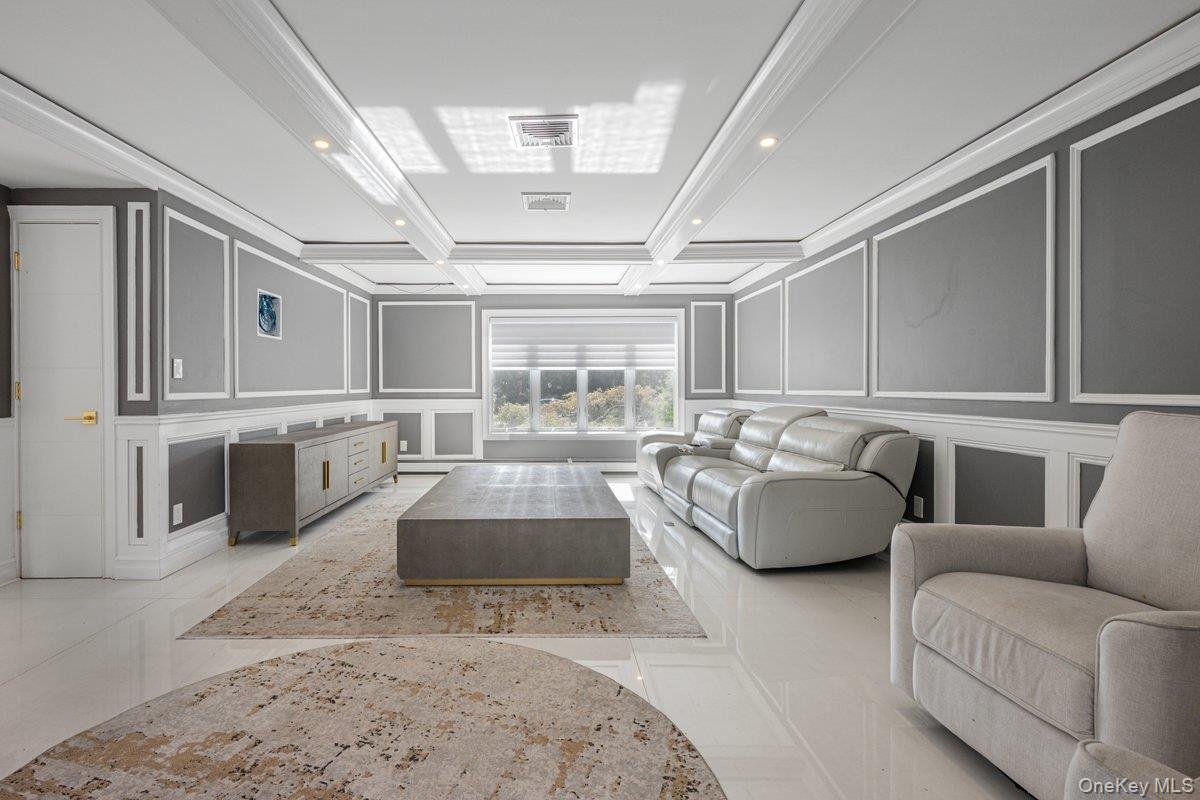Coffered ceiling featuring recessed lighting, extensive wall molding, and glossy tile flooring