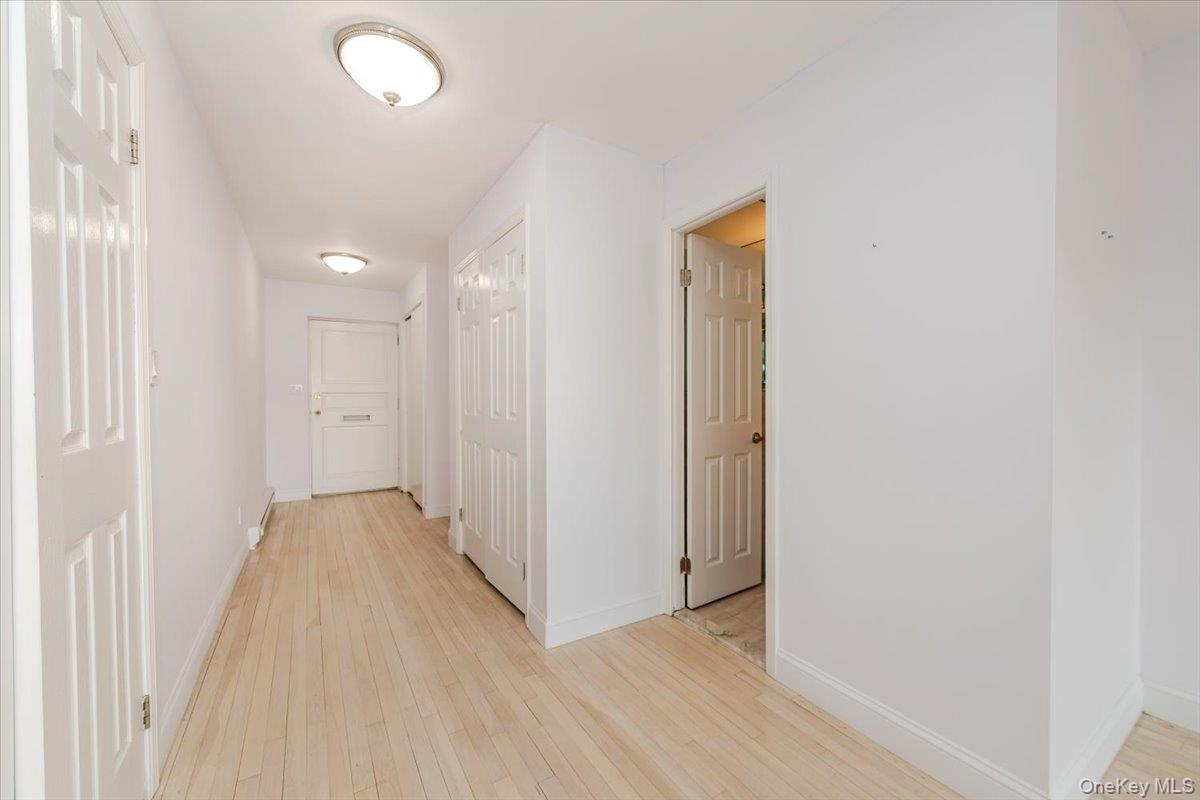 Hallway featuring light wood-style flooring and baseboards