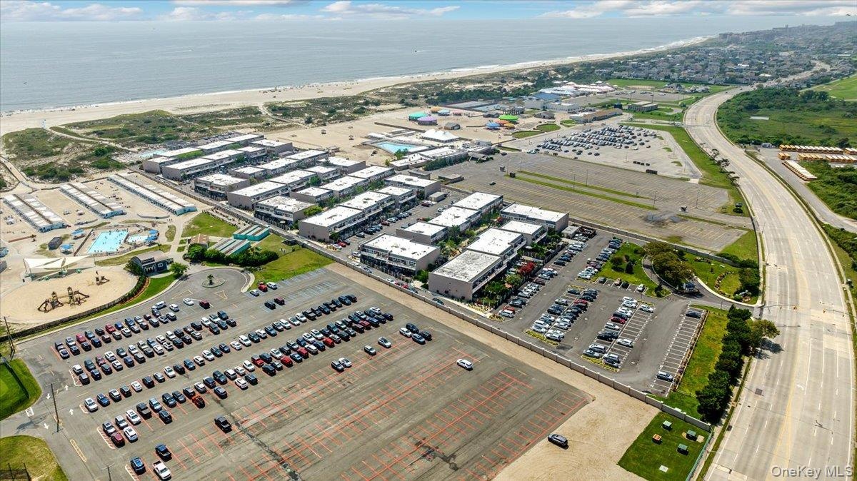 Birds eye view of property featuring a beach view and a water view
