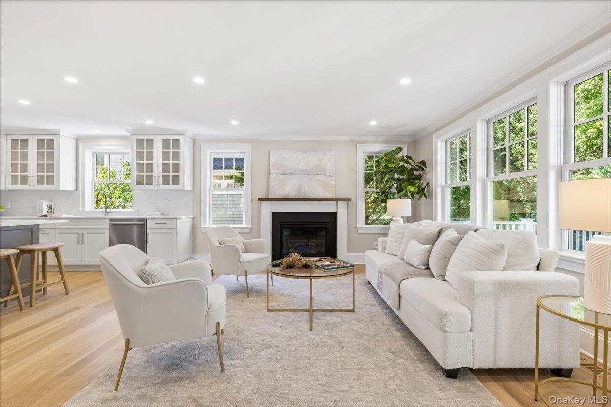 Large family room features gas fireplace, wall of large oversized windows, open to kitchen, french door leading to back deck and backyard.