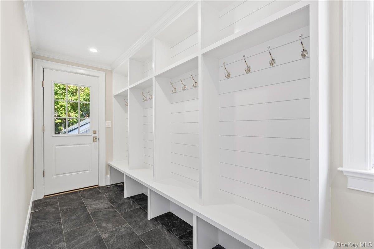 Large mudroom with custom built-ins and shiplap. Door leading to driveway and back yard. Perfect for everyday unloading of groceries, family etc... ea