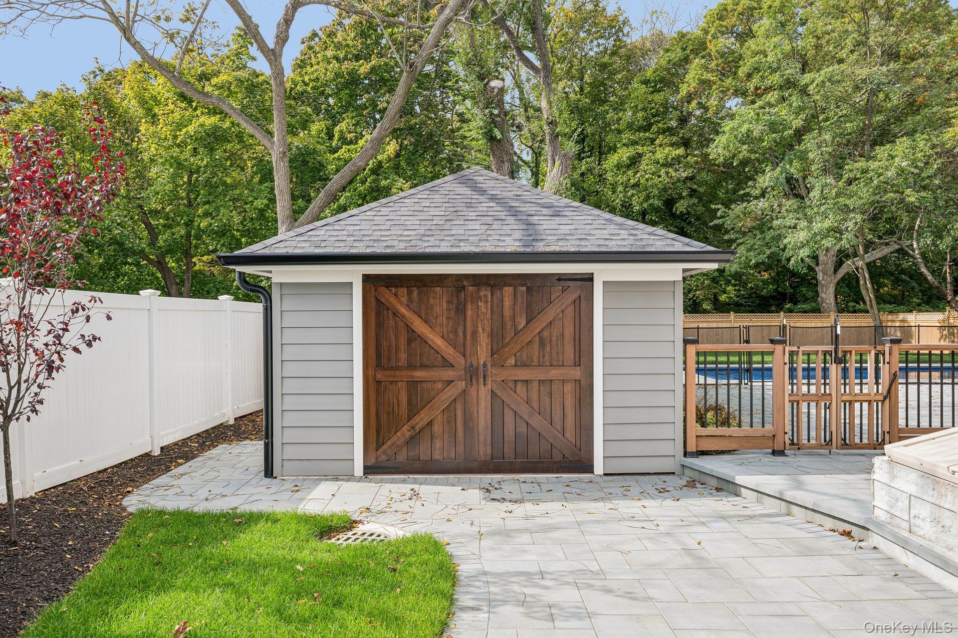 A detached garage with carriage-style door - could store kayaks, bikes and beach chairs, be used as a traditional garage or a pool house!  Blue Point 