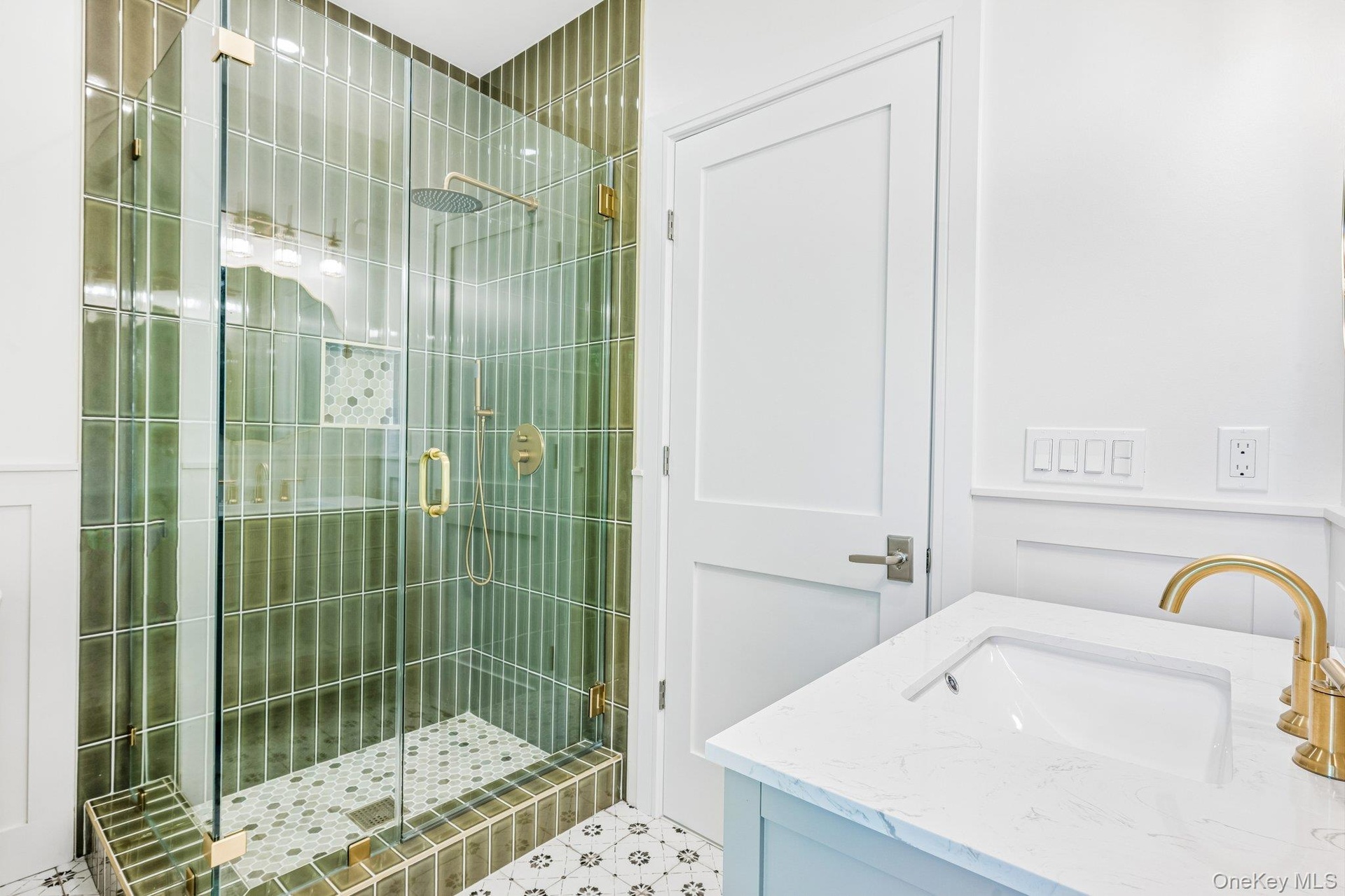 An emerald-tiled glass shower with brushed-gold fixtures. In summer, Bodhi's beach shack at Corey Beach, about 0.7 miles away, pours frozen cocktails 