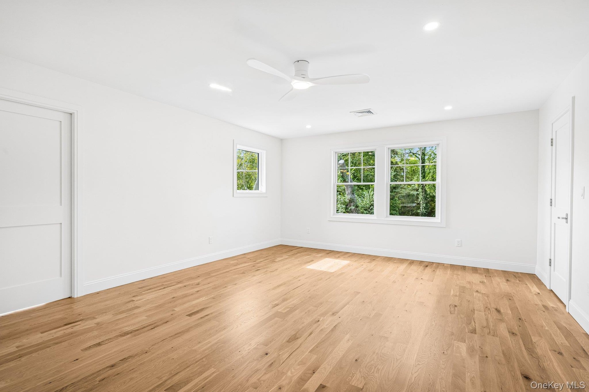 The primary suite, airy and calm. Mornings begin with a walk to the end of Nelson Avenue and the 20-acre Blue Point Nature Preserve, then a CoHo latte