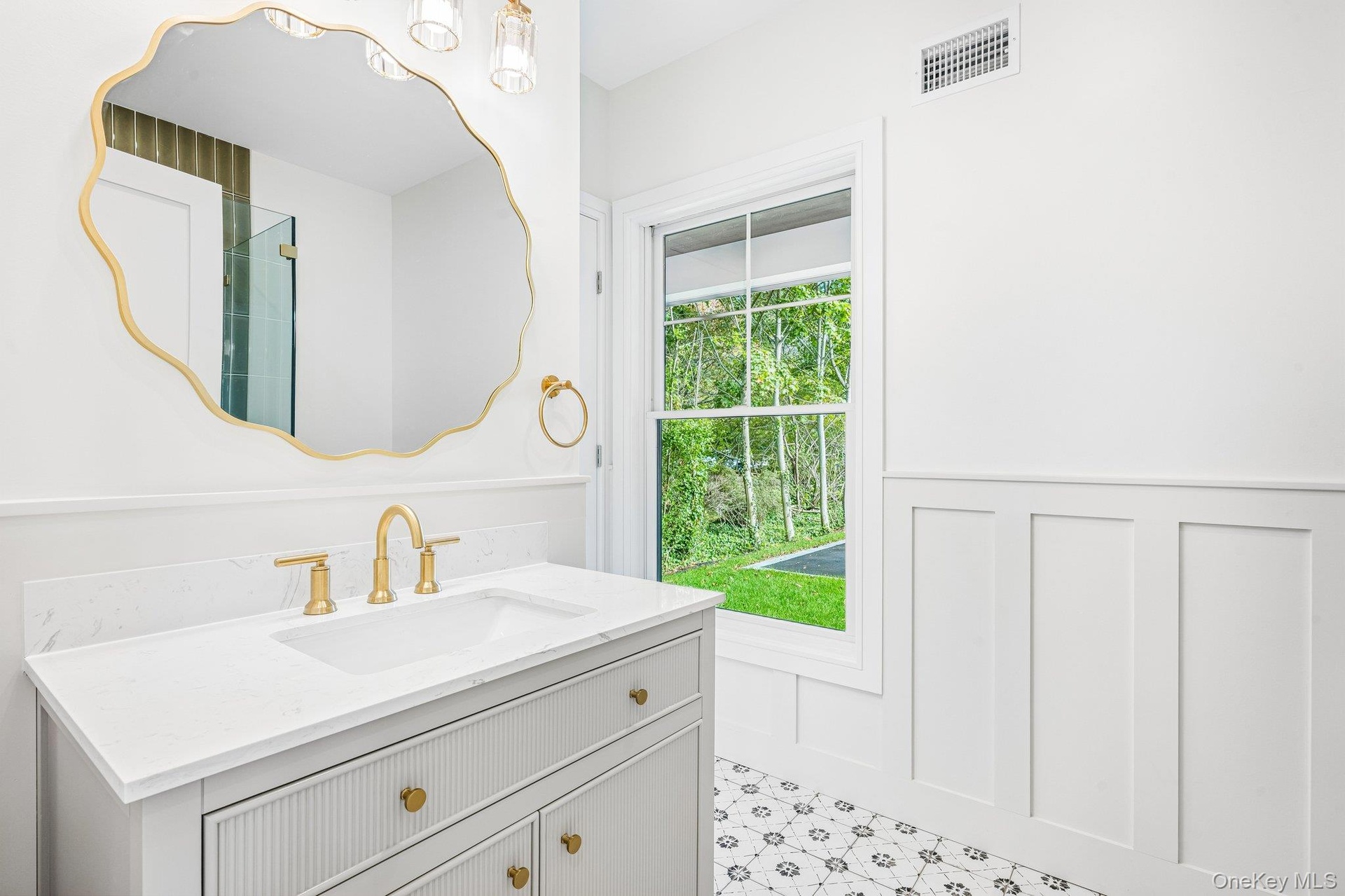 A sculpted gold mirror and white vanity bring jewel-box detail, made for an evening at the Blue Point Brewing tasting room on West Main Street in neig