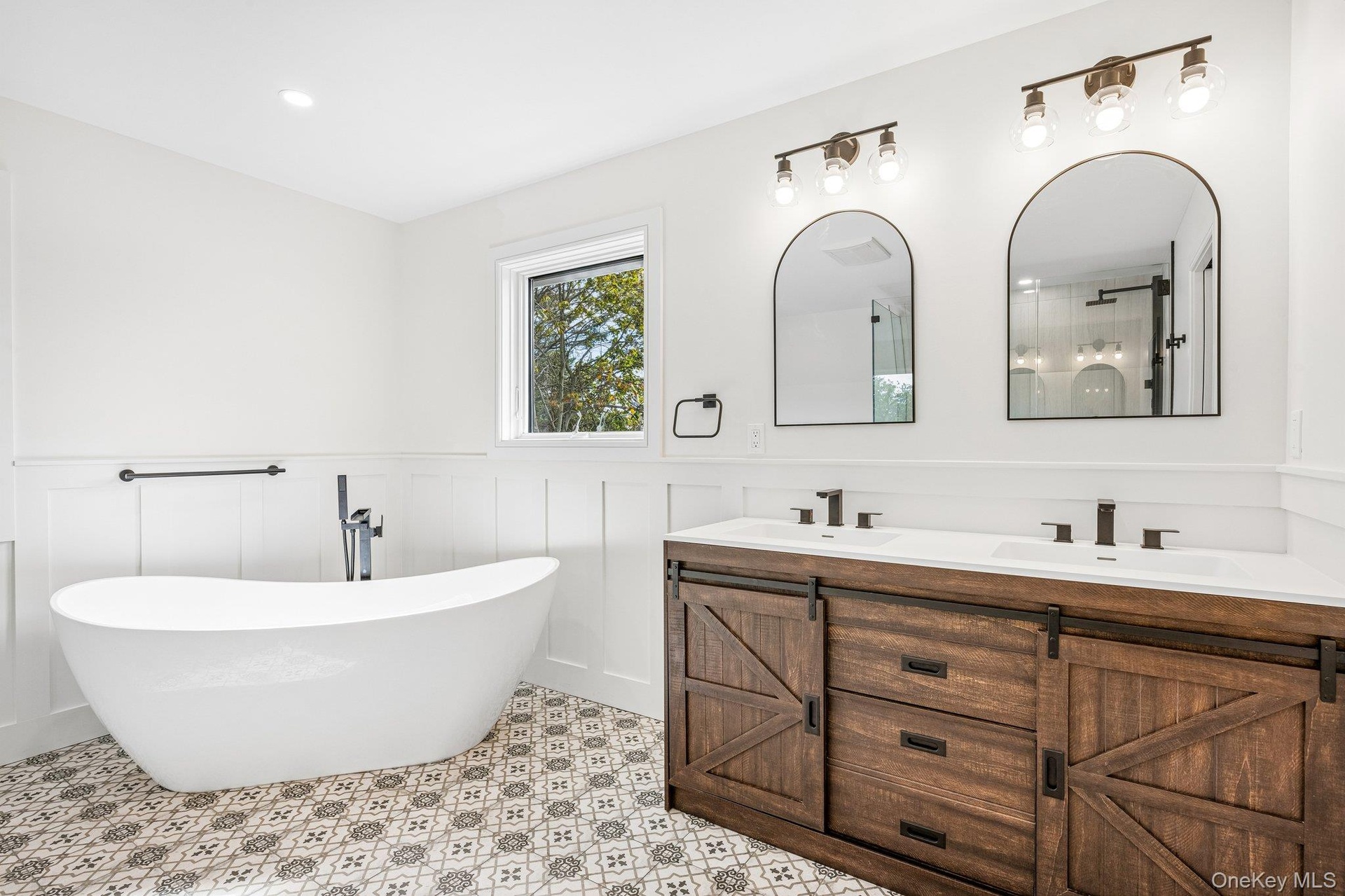 The primary bath: a freestanding soaking tub, patterned tile and a double vanity. Just as restorative, sunsets over the Great South Bay at the Blue Po