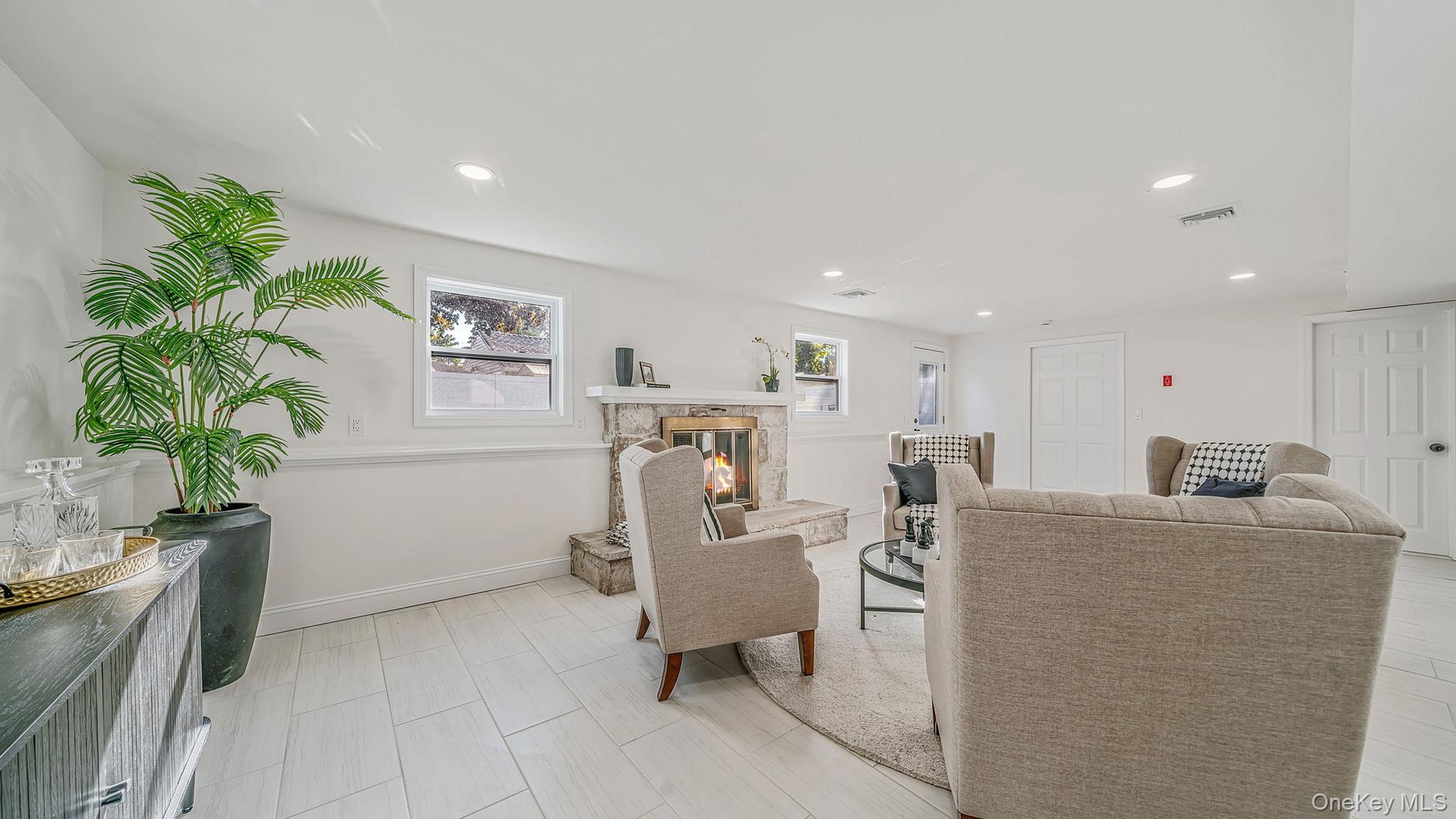 Family room with a stone-surround fireplace, recessed lighting and open space
