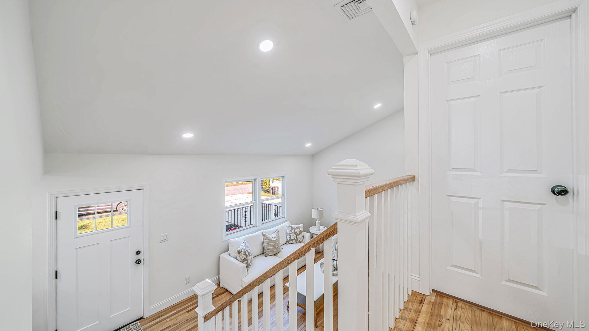 Hallway to 2nd floor showing a Vaulted ceiling