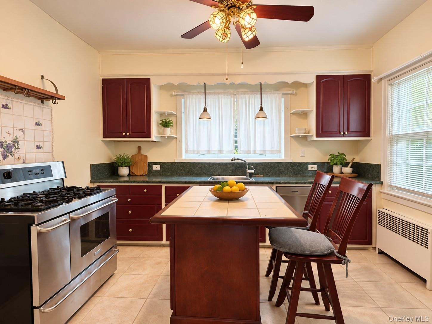 Kitchen featuring solid-color cabinetry, stone-finish countertops, professional-grade stainless steel range, ceramic-tiled kitchen island, and ceramic