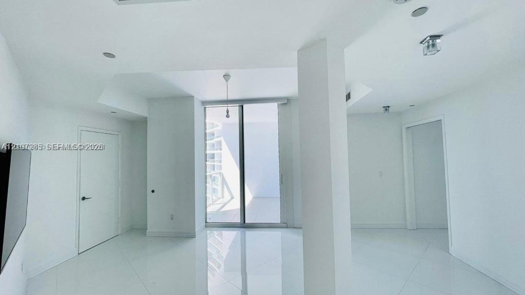 High-gloss floor tiling, ceiling-height glass sliding doors, structural architectural pillar, and recessed ceiling lighting