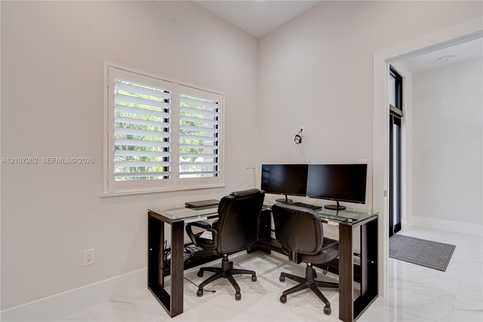 Neutral wall finishes, white plantation shutters, and large-format tile flooring