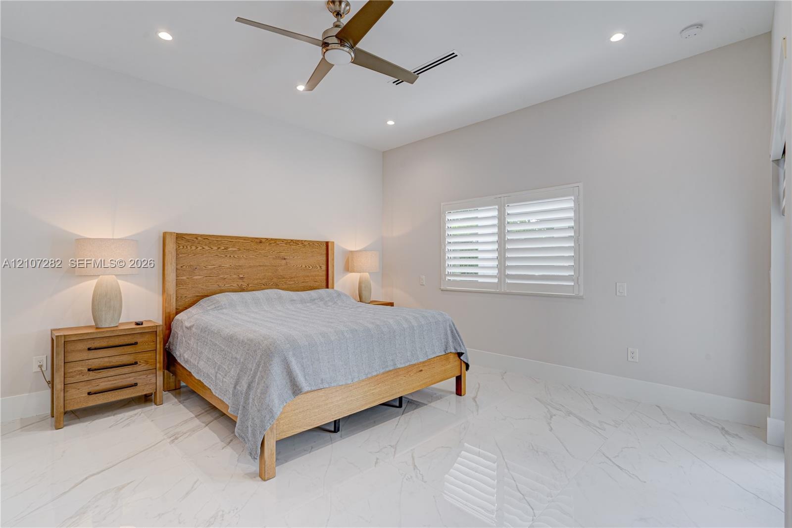 High ceilings, polished stone-finish flooring, recessed lighting, ceiling fan, and plantation shutters
