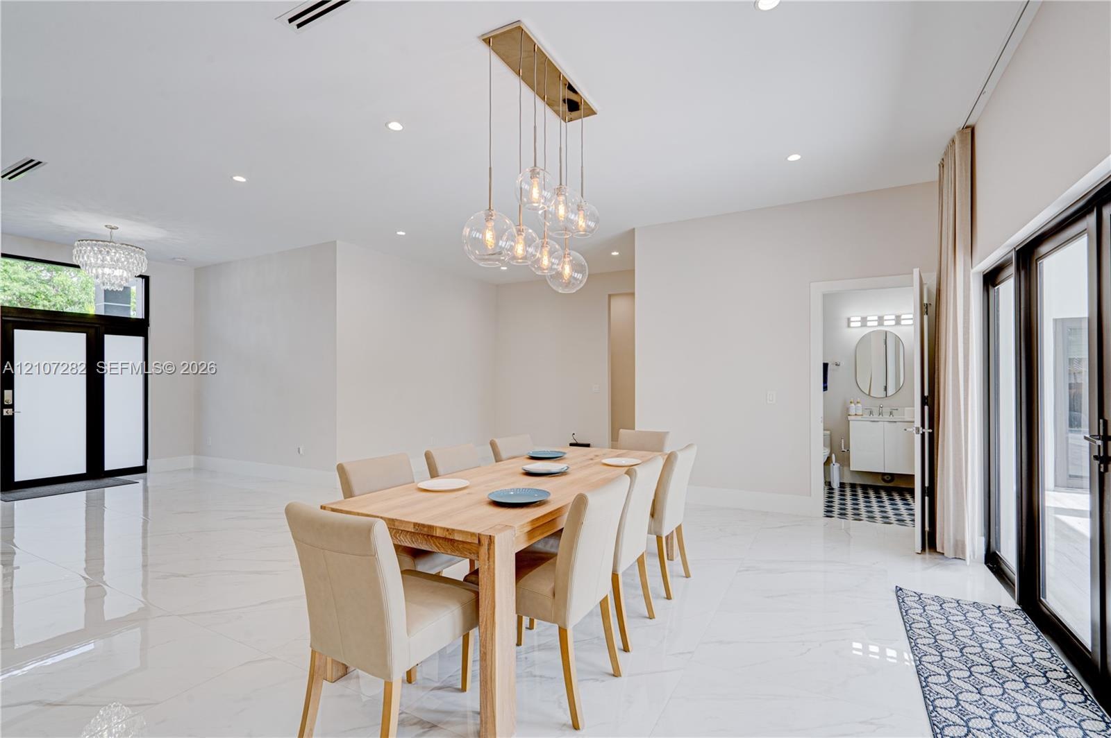 Large-format tile flooring, multi-light glass pendant fixture, recessed lighting, and multi-panel glass door systems