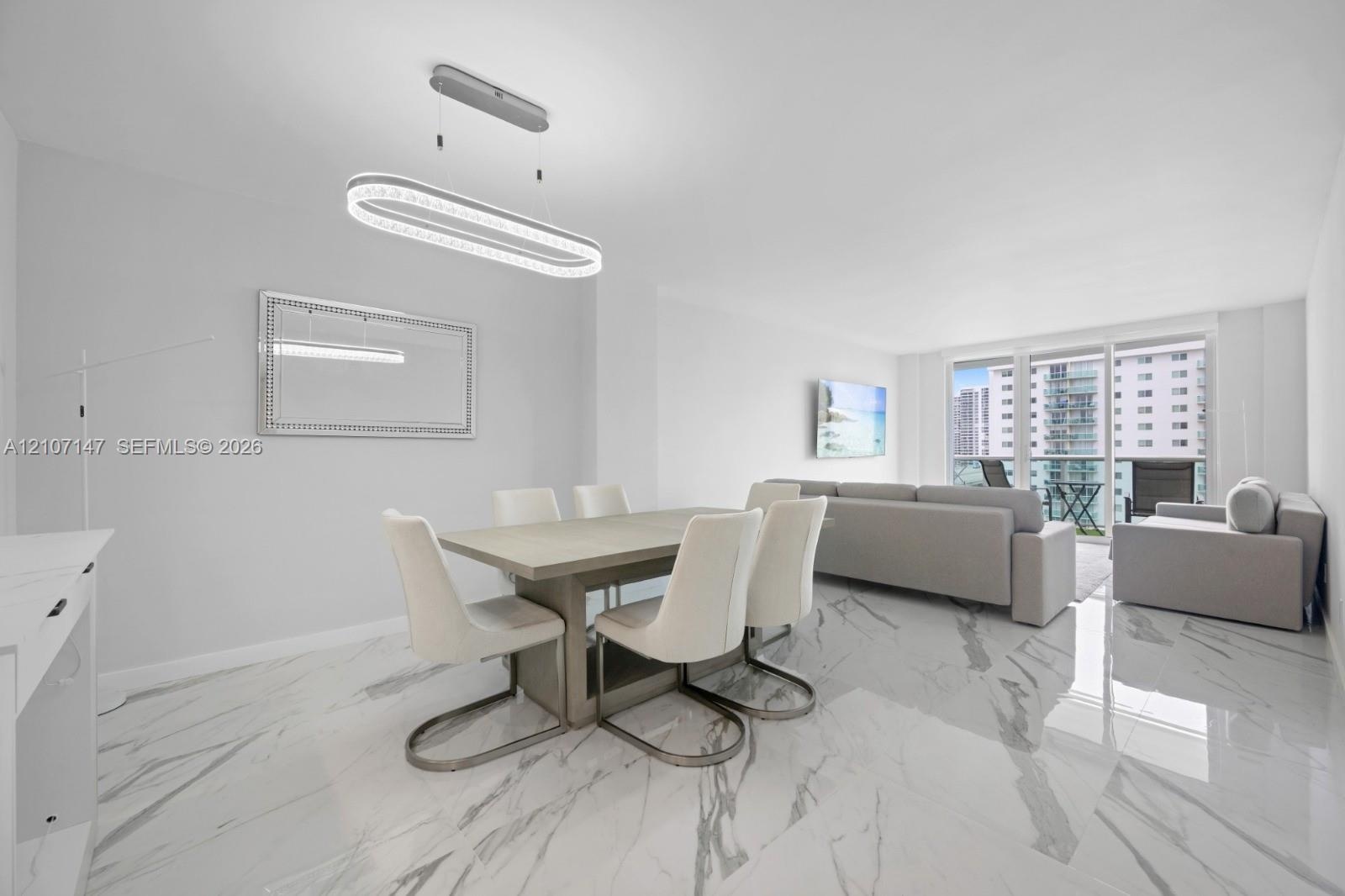 Polished stone-finish flooring, modern oval LED pendant lighting, and full-height glass balcony doors