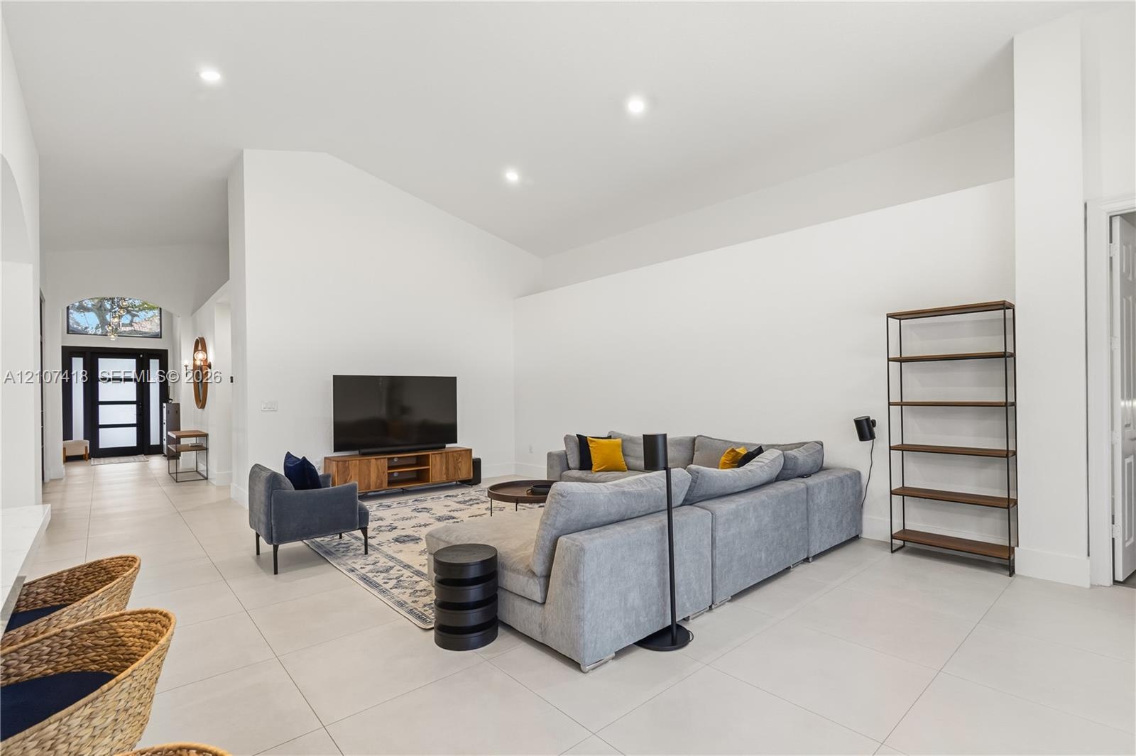 Vaulted ceilings, neutral ceramic tile flooring, recessed lighting, and a multi-pane glass entry door