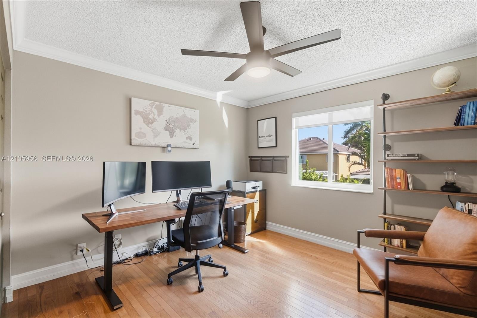 Room featuring wood-finish flooring, a matte finish ceiling fan with integrated lighting, and a single-pane window