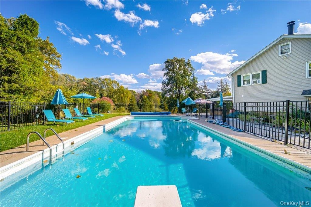 Diving board, paver surround and wrought iron fencing elevate this amazing pool experience.