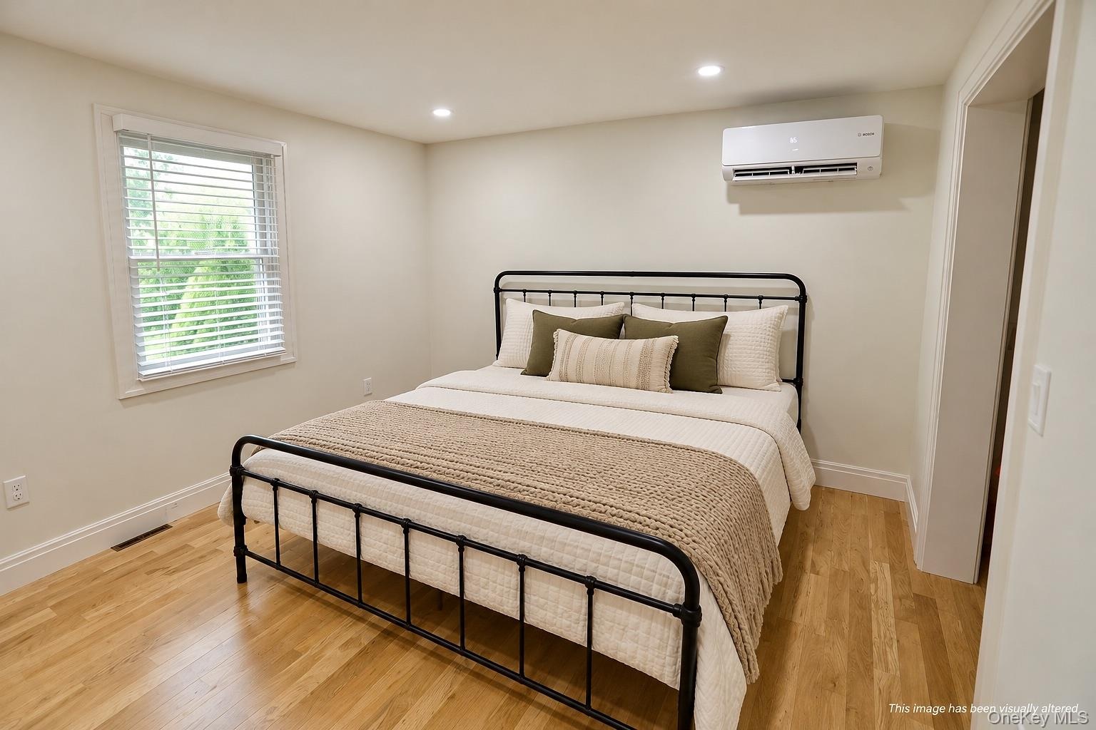 Wood-finish flooring, recessed lighting, mini split, and double-pane window with horizontal blinds