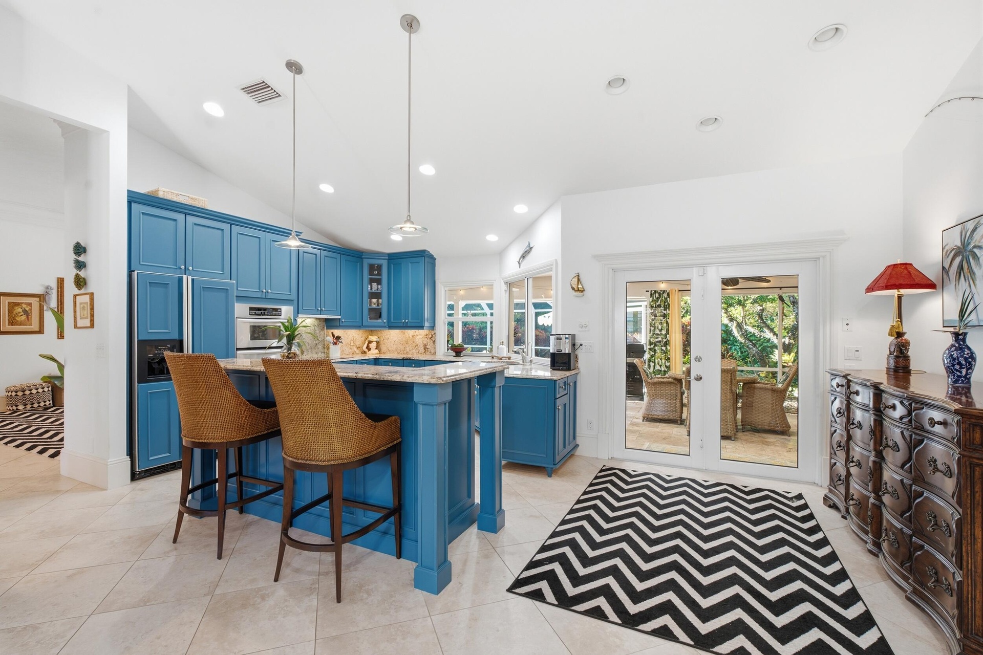 Kitchen featuring custom blue cabinetry, a center island with stone countertops, recessed lighting, and dual glass-paned doors