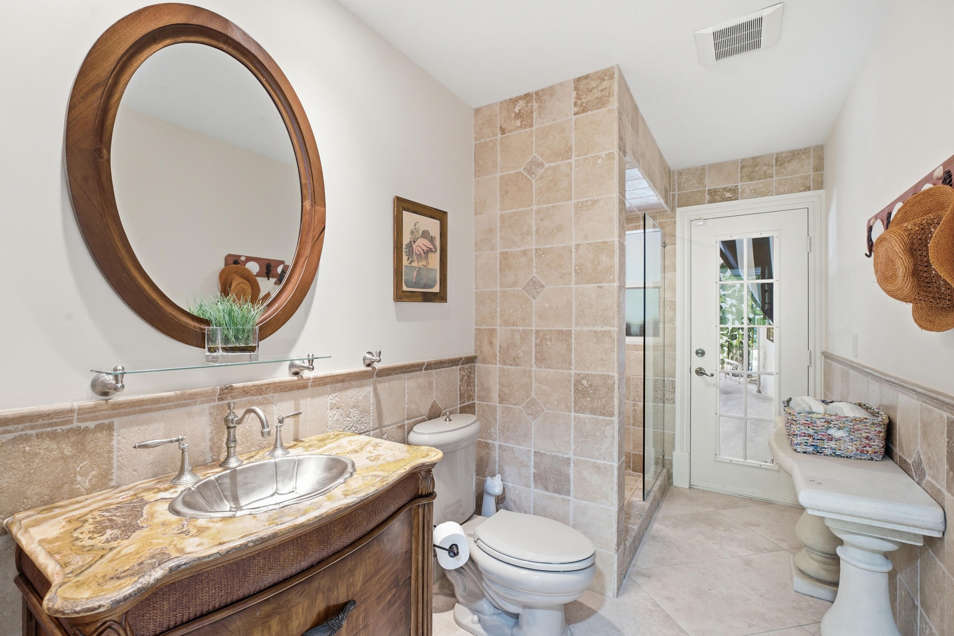 Bathroom featuring a custom wood vanity with an ornate stone countertop and integrated metallic sink, complemented by a stone-tile shower enclosure an