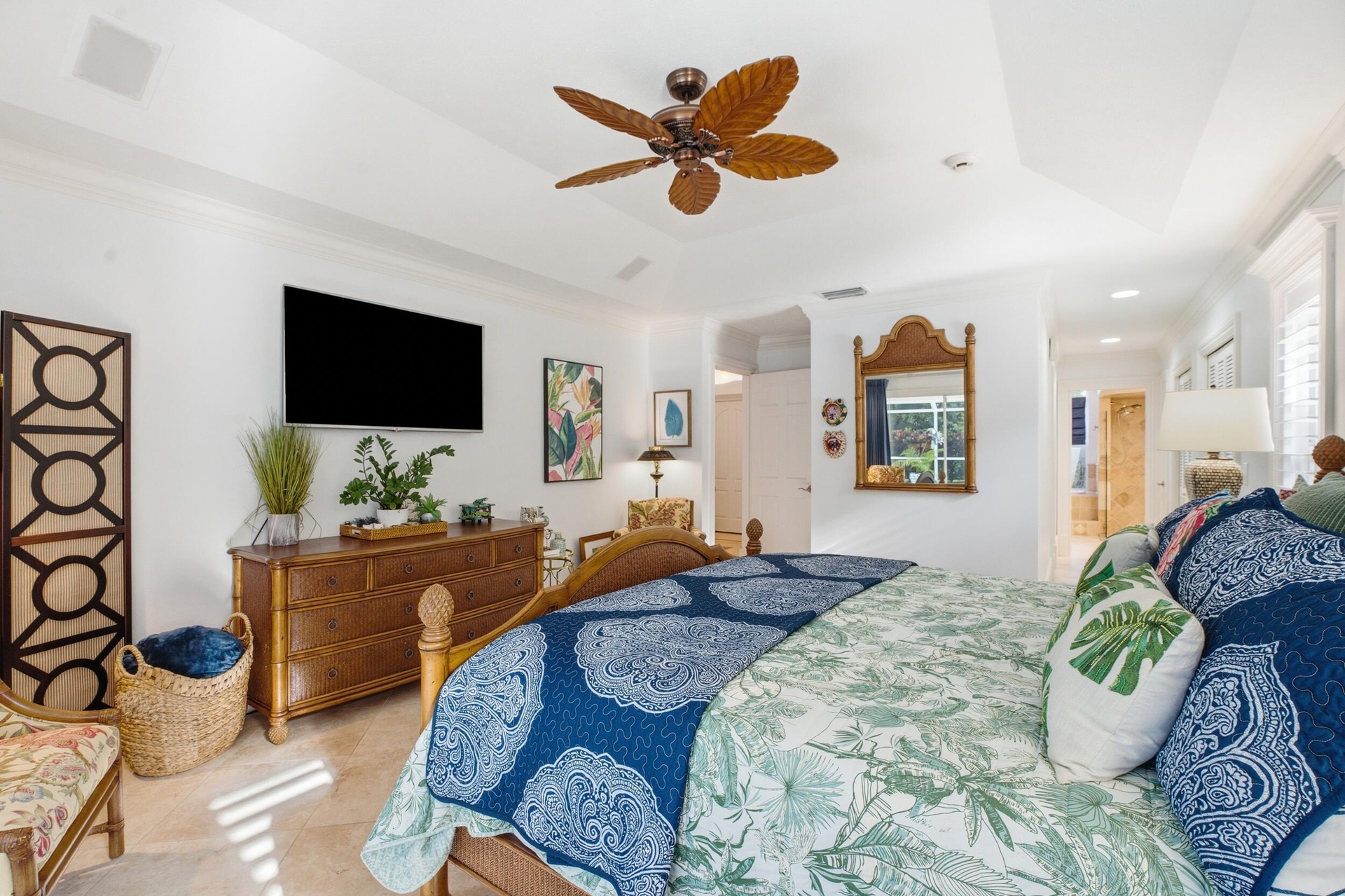 Tray ceiling with recessed lighting and multi-blade ceiling fan featuring organic-inspired design, stone tile flooring, and shutter window coverings