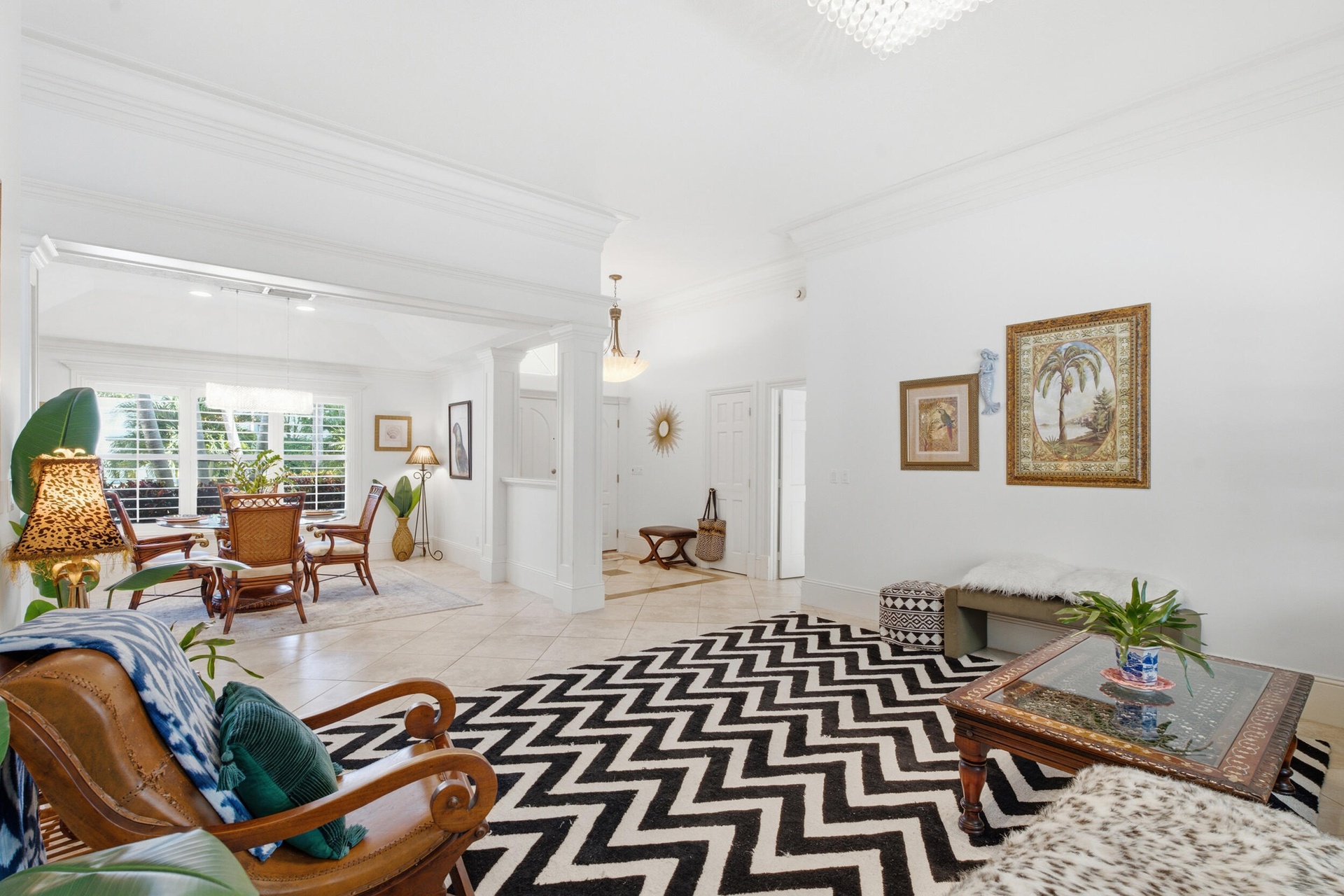 Open-concept interior featuring oversized tile flooring, crown molding, structural columns, and recessed lighting