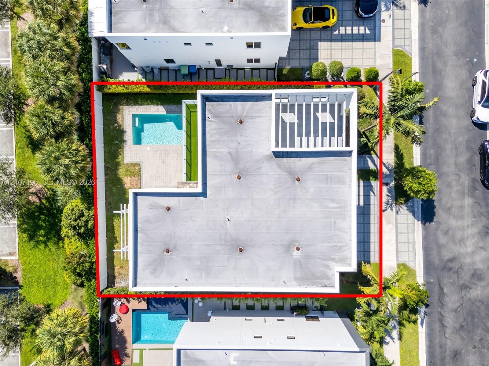 Aerial perspective featuring a private swimming pool, concrete paver patio, structural pergola, and perimeter hedge landscaping