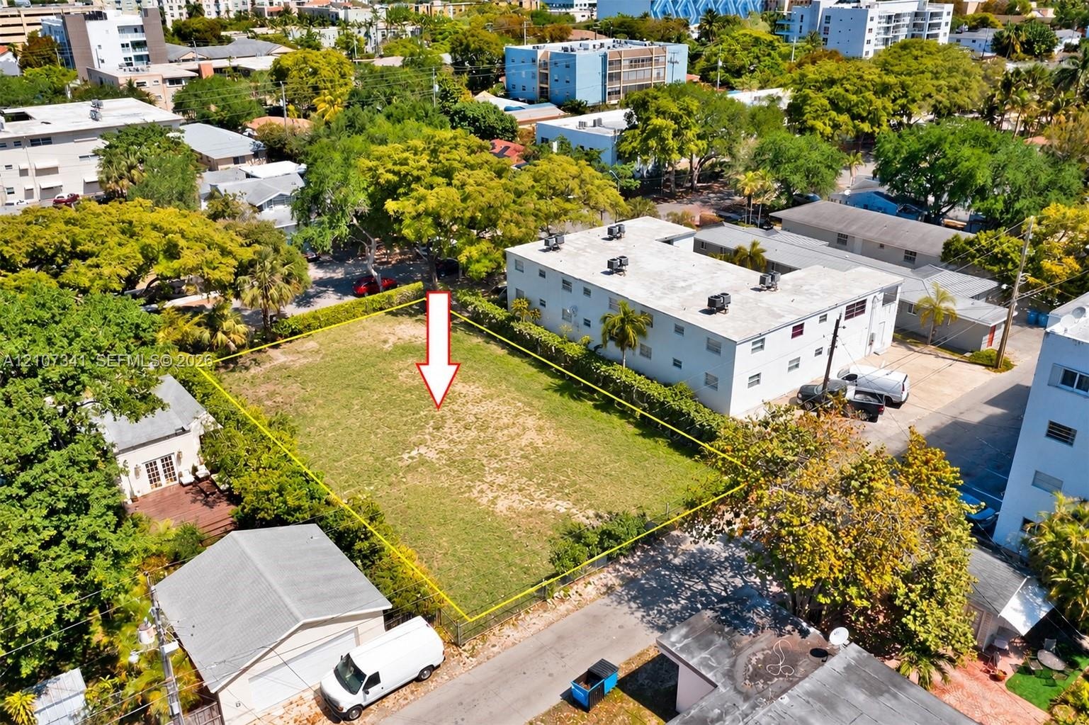 Vacant residential lot featuring perimeter landscaping and mature trees