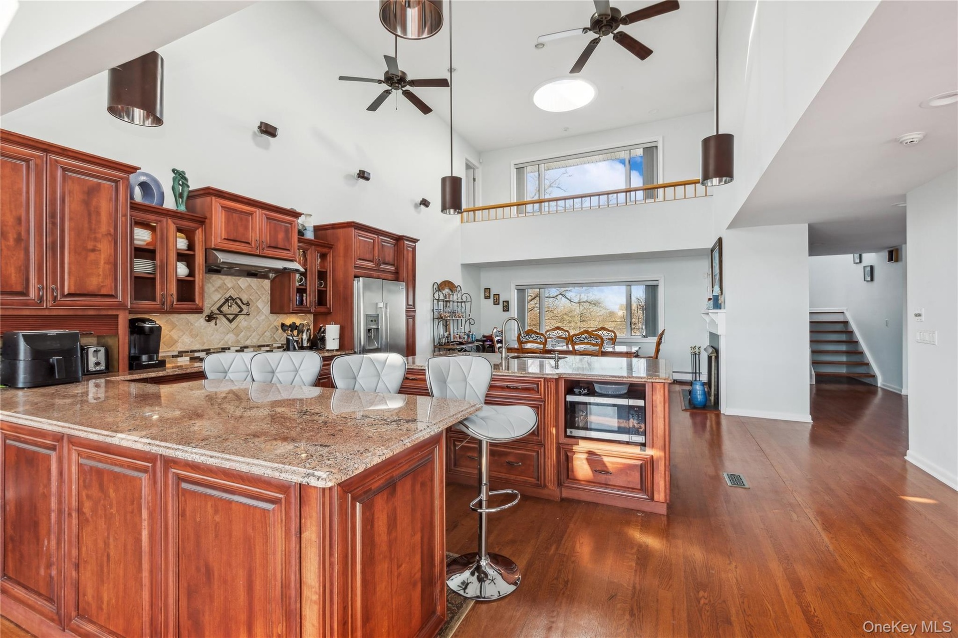 Kitchen featuring sink, a breakfast bar area, ceiling fan, stainless steel appliances, and decorative backsplash