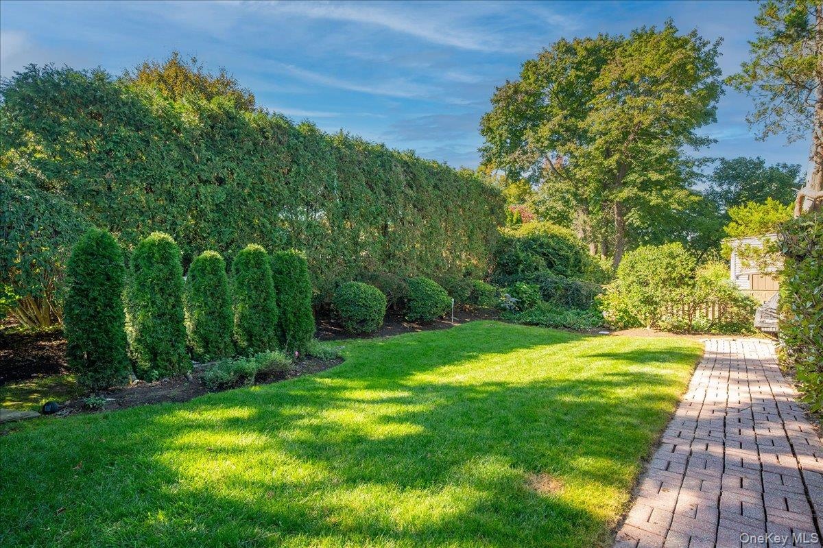Brick walkway to a private and perfectly manicured yard