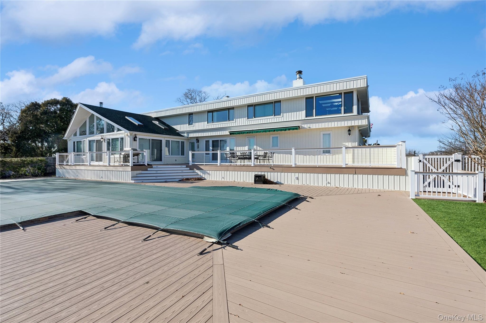 Rear view of house with a pool side deck and a patio area