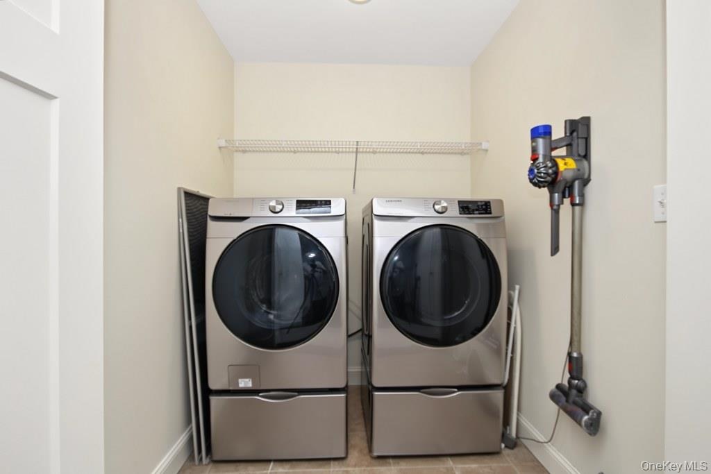 Dedicated 2nd floor laundry area featuring a front-loading washer and dryer set