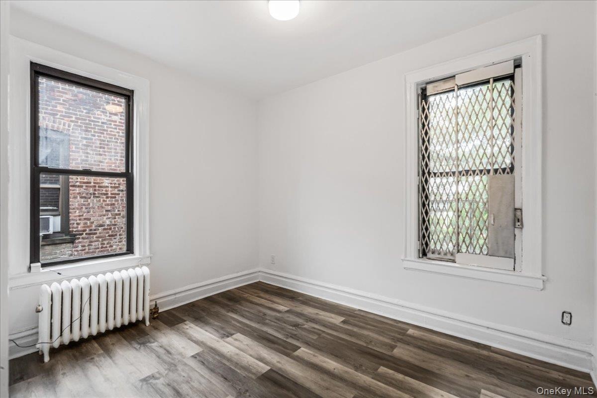 Spare room featuring radiator heating unit and wood finished floors