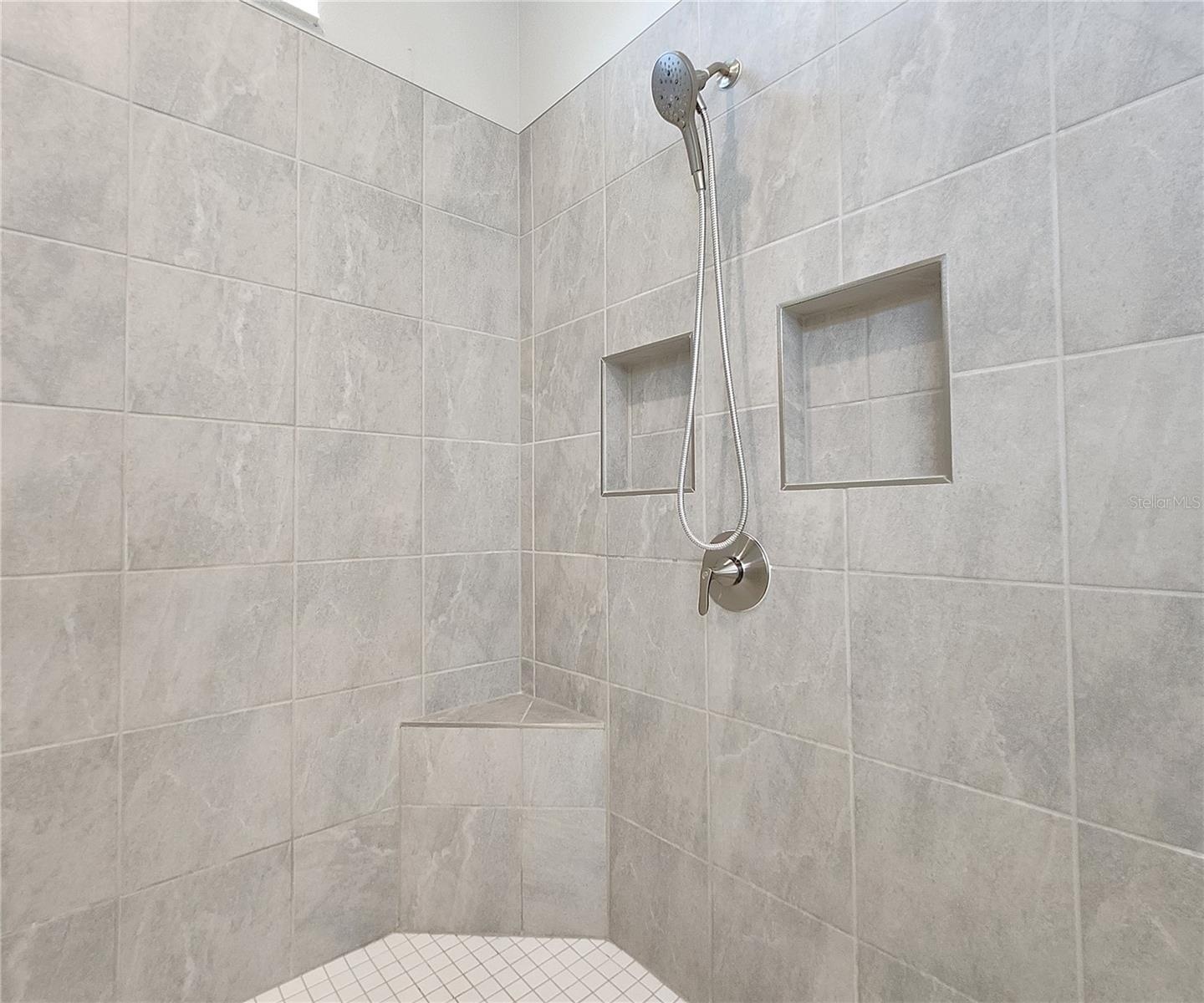 Master bathroom includes large walk-in  tiled shower, water closet, walk-in closet, dual sink vanity, granite countertops