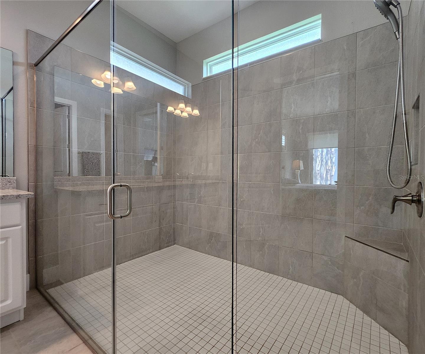 Master bathroom includes large walk-in  tiled shower, water closet, walk-in closet, dual sink vanity, granite countertops