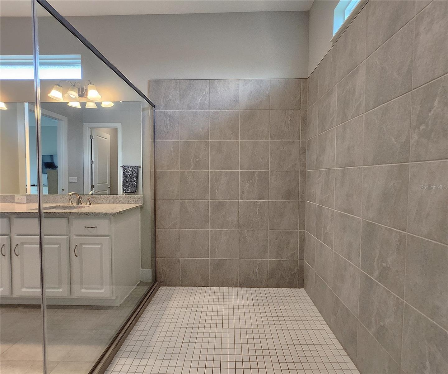 Master bathroom includes large walk-in  tiled shower, water closet, walk-in closet, dual sink vanity, granite countertops
